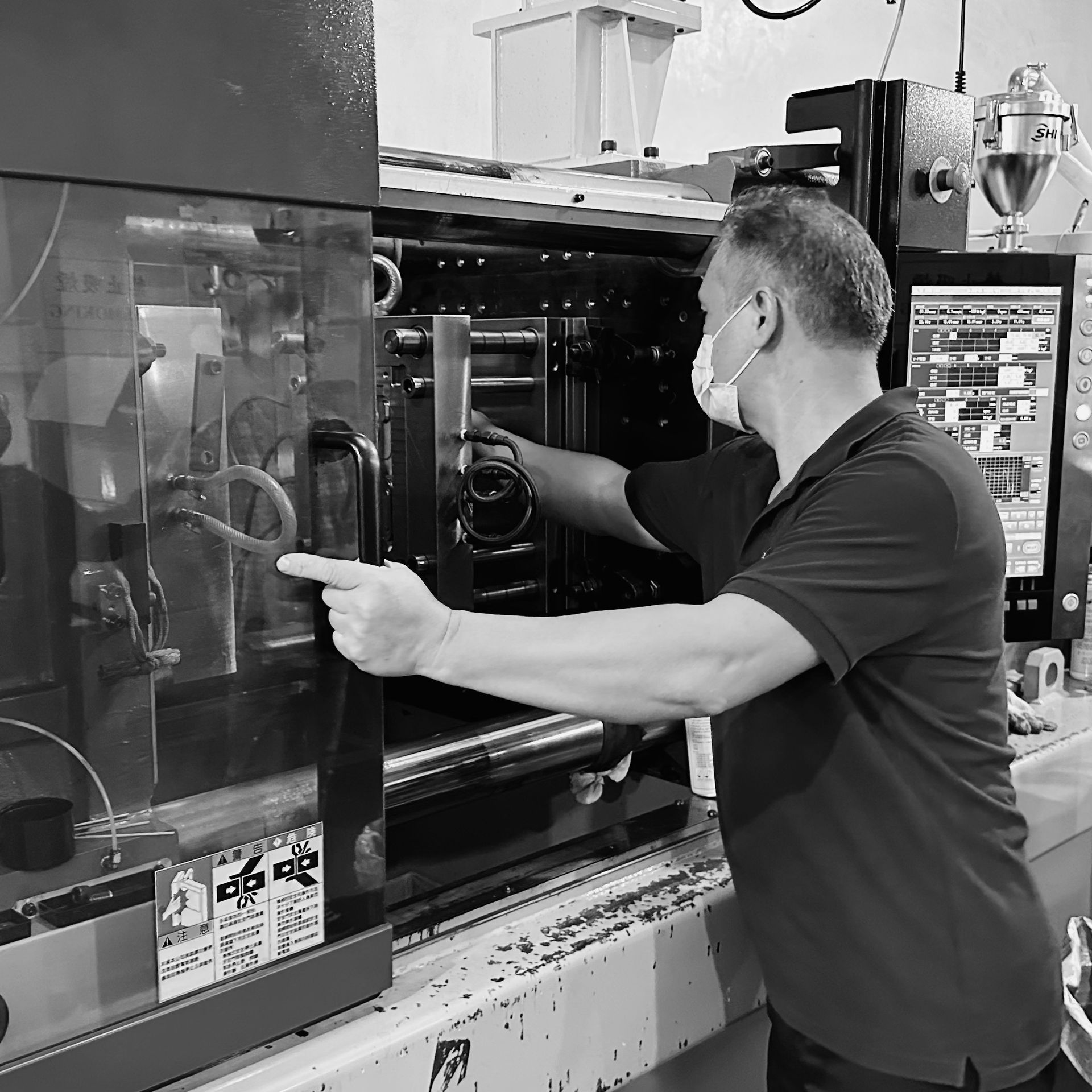 A man working with a injection molding machine