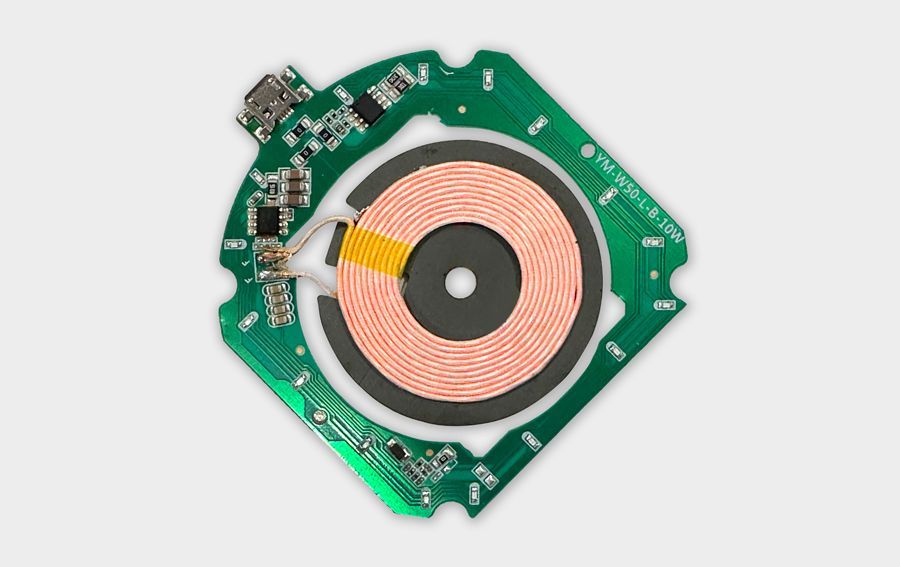 A wireless charging circuit board with a copper coil mounted on a green printed circuit board.