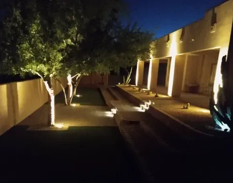 Pathway landscape lighting illuminating a walkway through a landscaped yard