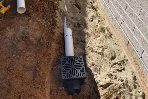 Landscape drainage solution managing excess water around an outdoor area