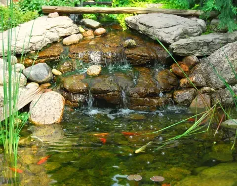 Landscape water feature enhancing the design of a landscaped outdoor area
