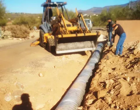 Drainage system installation designed to manage water across a landscaped yard
