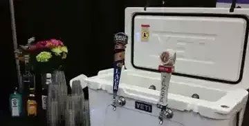 A white yeti cooler with beer taps attached to it.