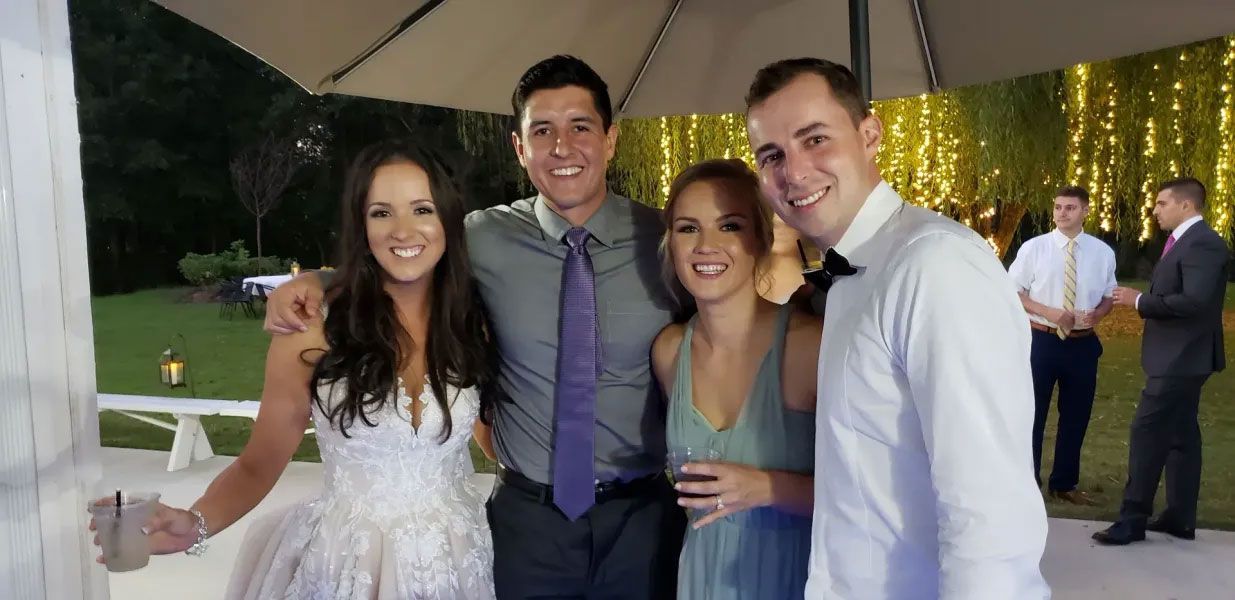 A group of people are posing for a picture at a wedding.