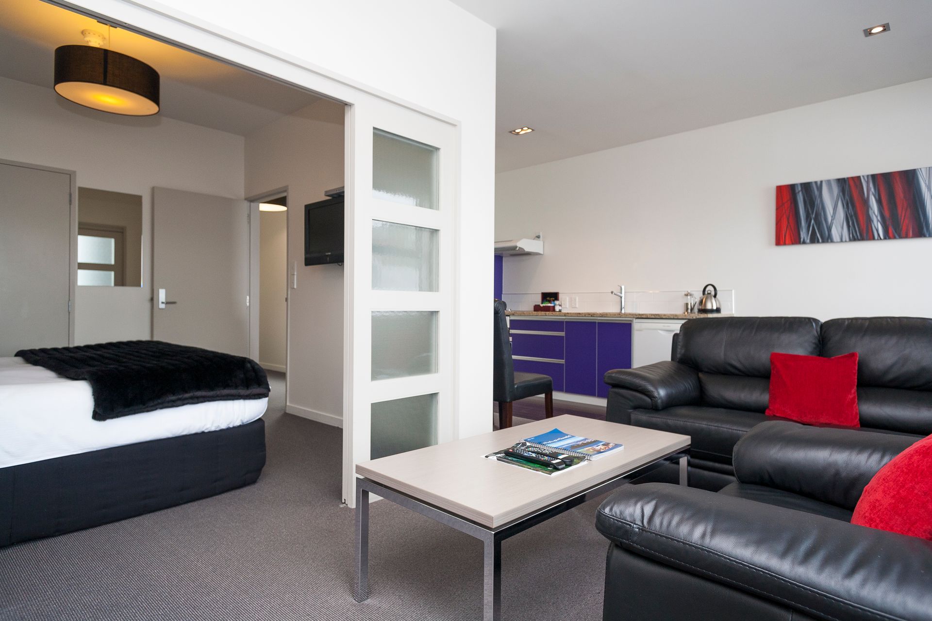 A living room with a couch a table and a bed
