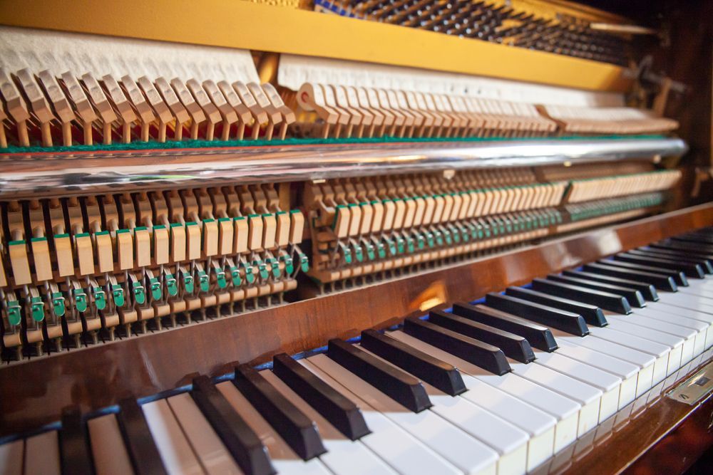 A close up of the inside of an upright piano.