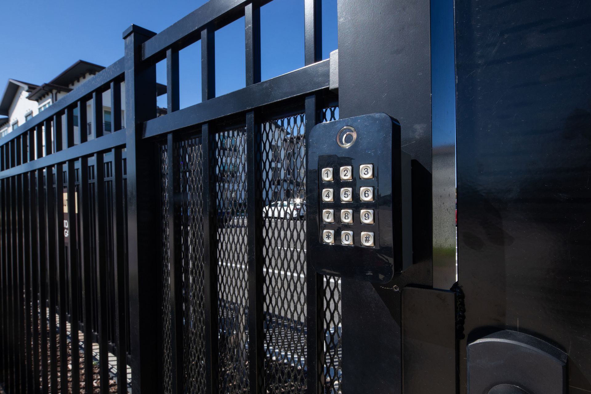 A black metal security gate featuring an electronic keypad for access control.