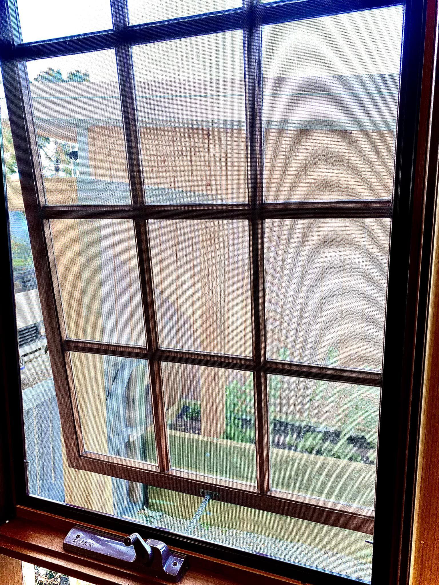 A Window With a Brown Grid Frame — Rodens Repairs Flyscreens and Doors In Forcett, TAS