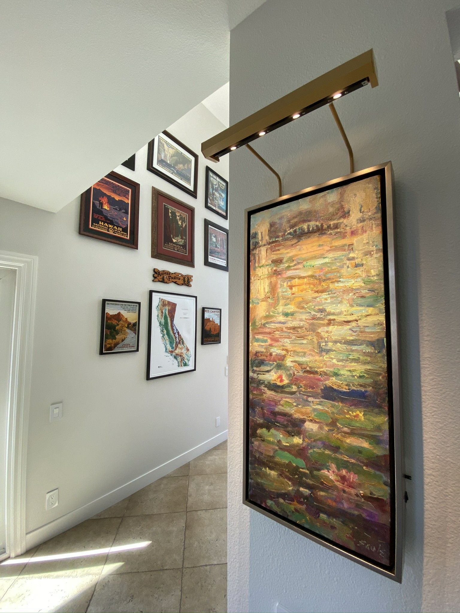 A hallway with paintings on the wall and a painting hanging on the wall.