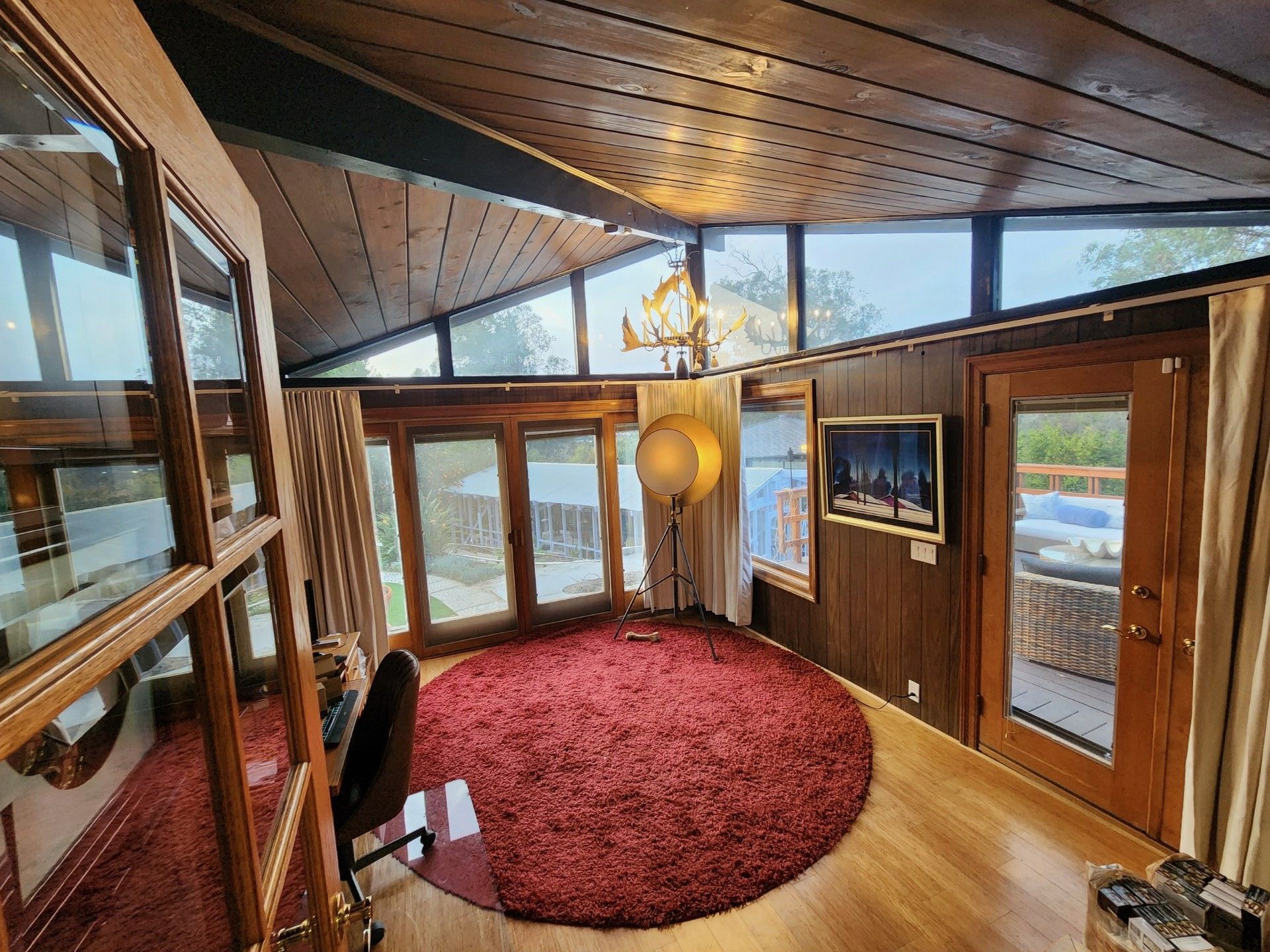 A living room with a round rug and a large window.