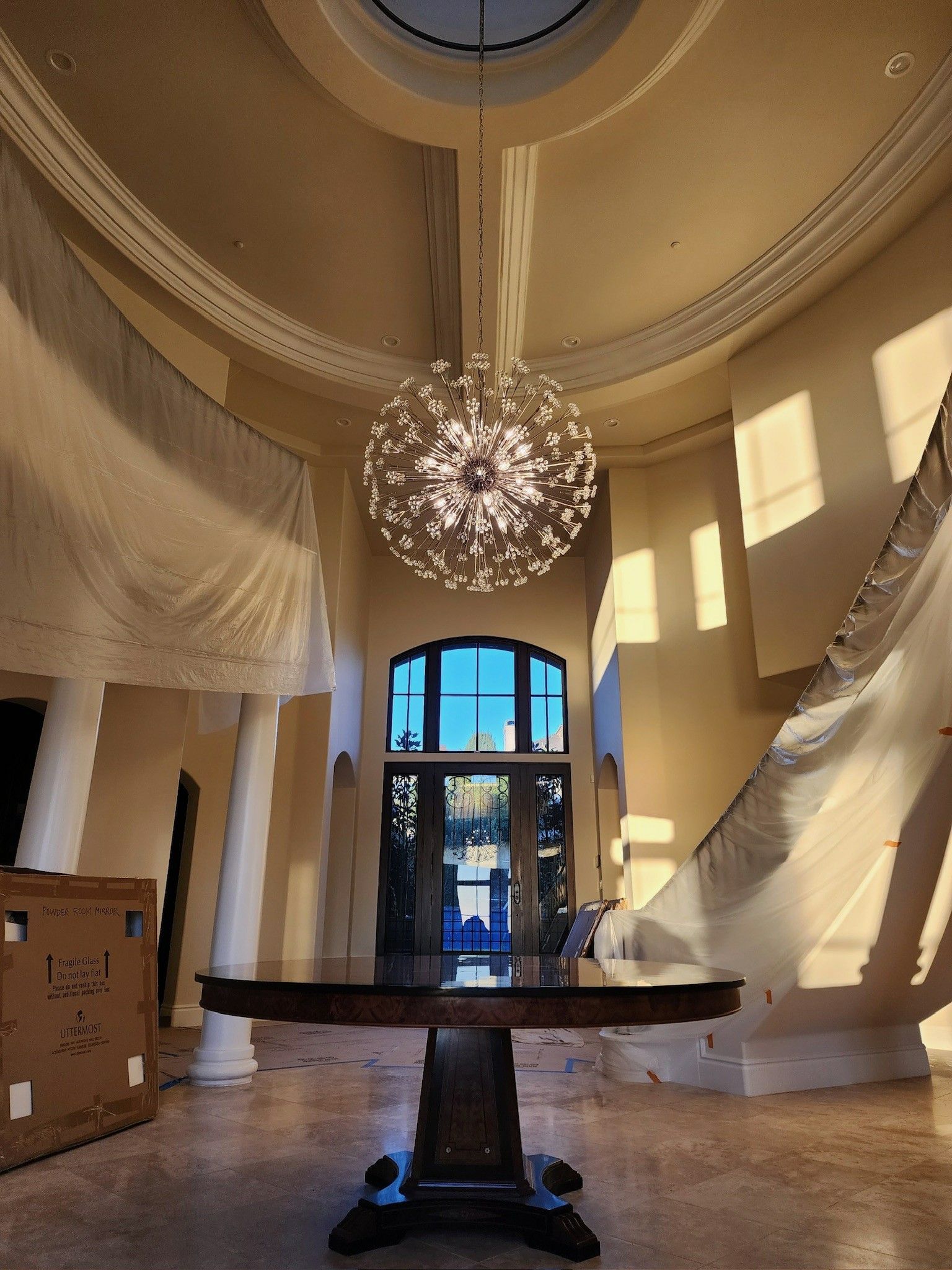 A large room with a table and a chandelier hanging from the ceiling