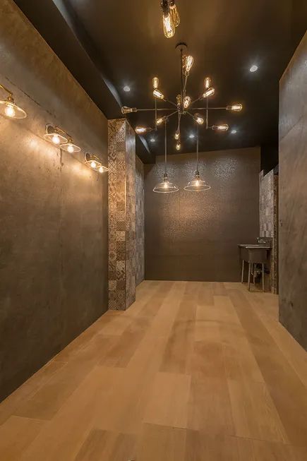 An empty room with a wooden floor and a chandelier hanging from the ceiling.