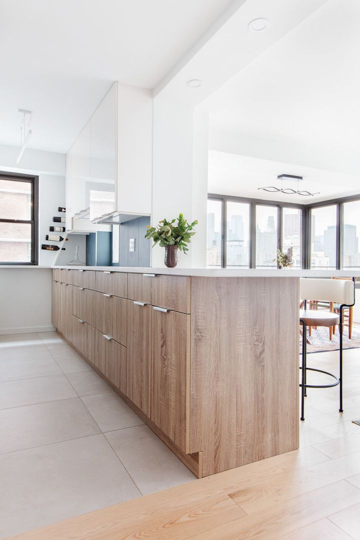 A kitchen and living room in a house with blue cabinets and hardwood floors.