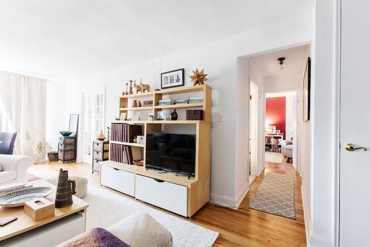 A living room with a wooden entertainment center and a flat screen tv.