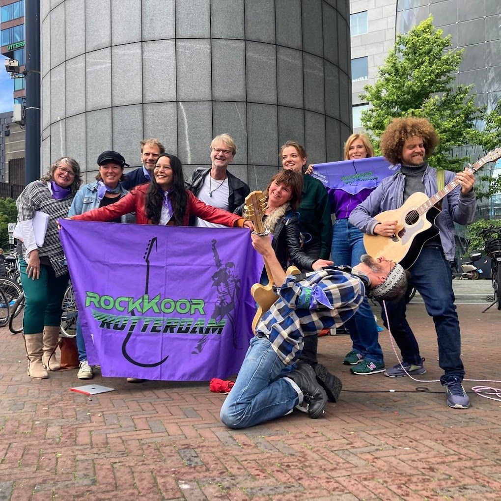 Leden van RockKoor Rotterdam buiten met paarse vlag en gitaar