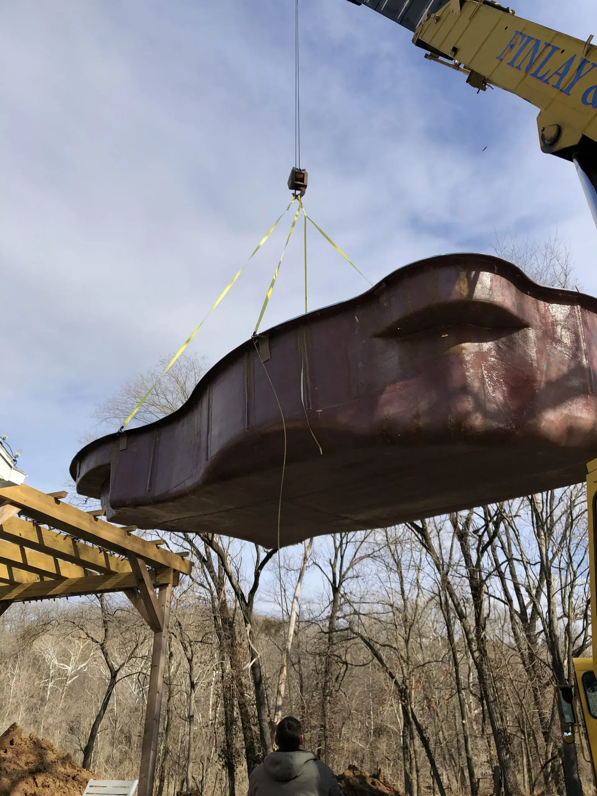 fiberglass pool being lowered into ground by crane