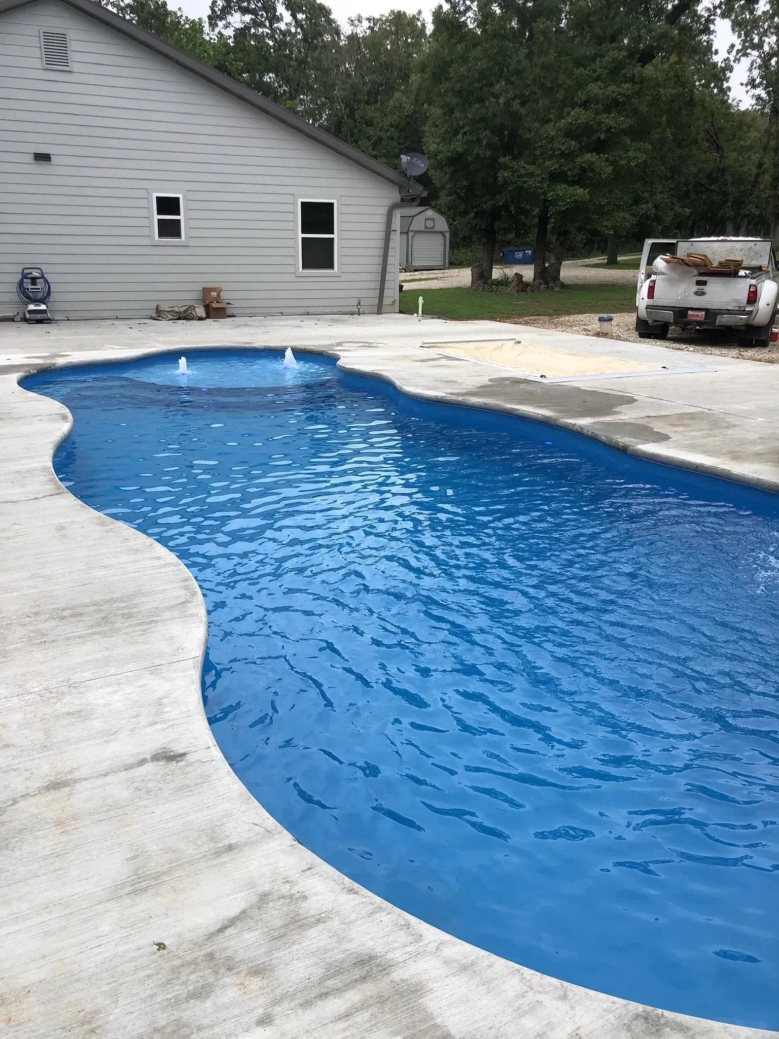 freeform pool with water feature in a backyard
