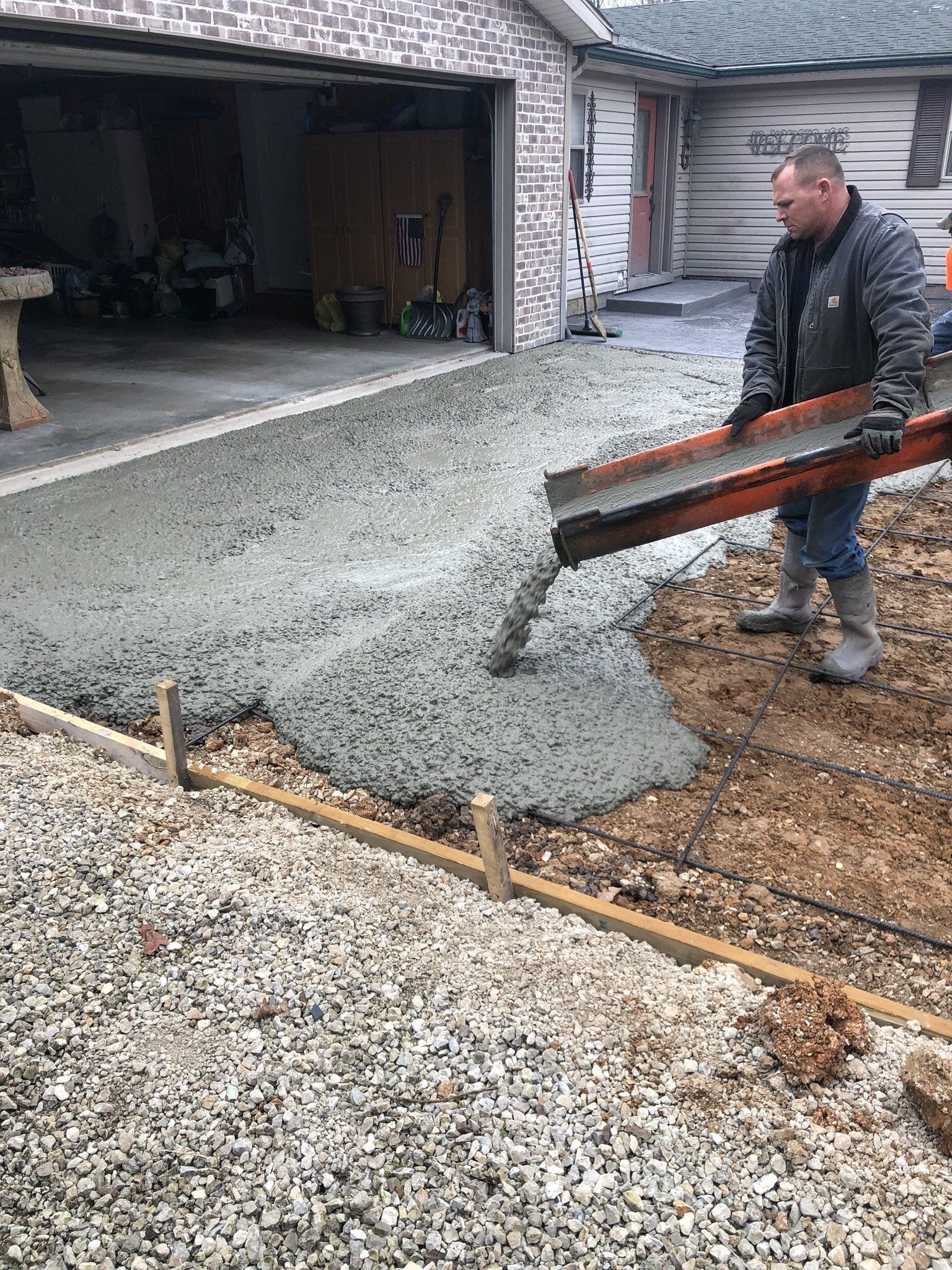 man in work boots pouring wet concrete 