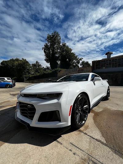 A white car is parked in a parking lot.