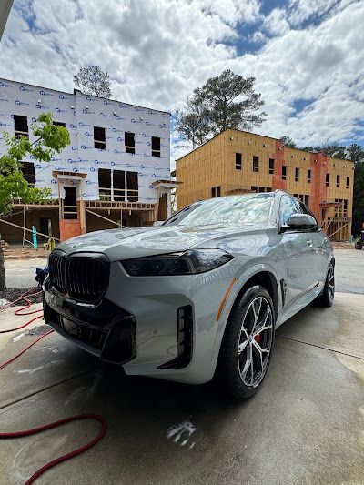 A bmw x5 is parked in front of a building under construction.