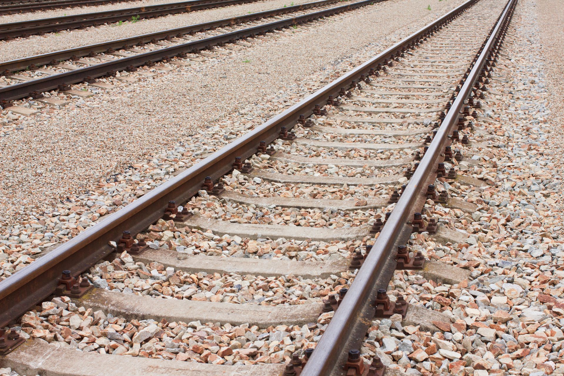 Railroad tracks extending into the distance, set on gravel.