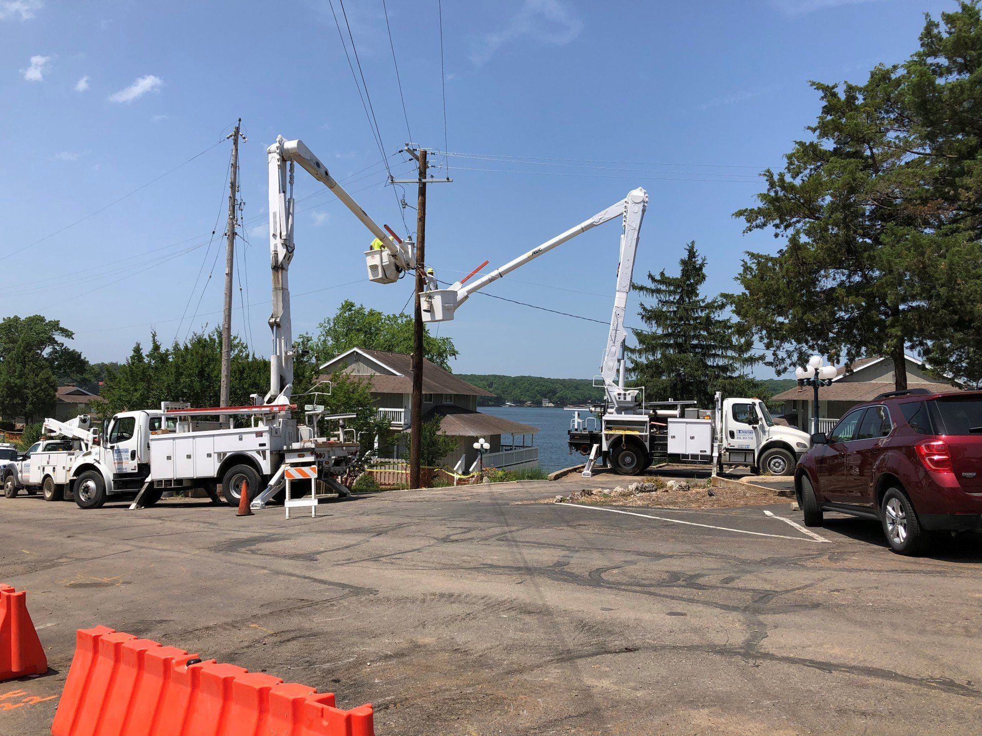 A row of utility trucks are parked in a parking lot.