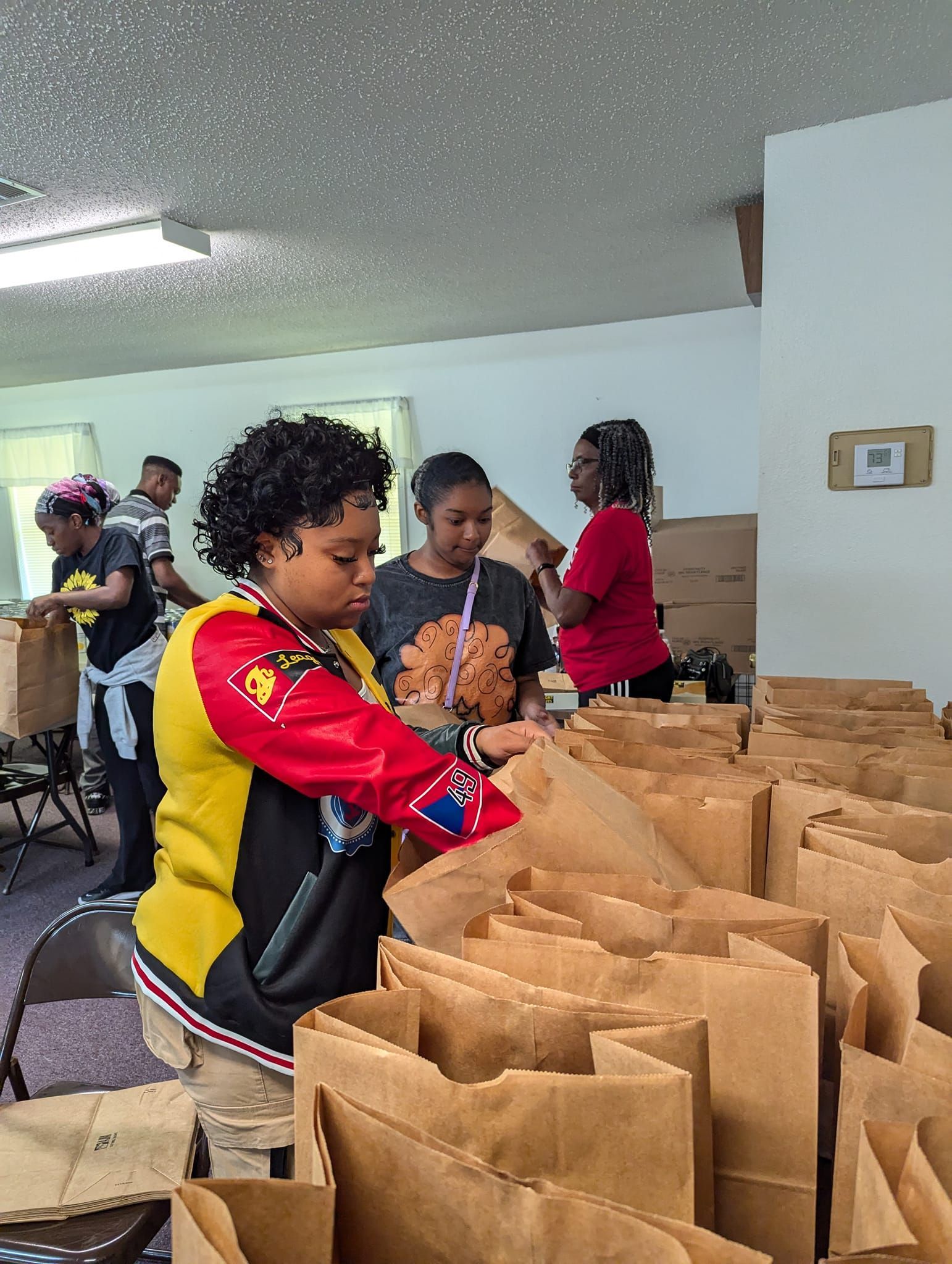 A group of people are working in a room filled with paper bags.