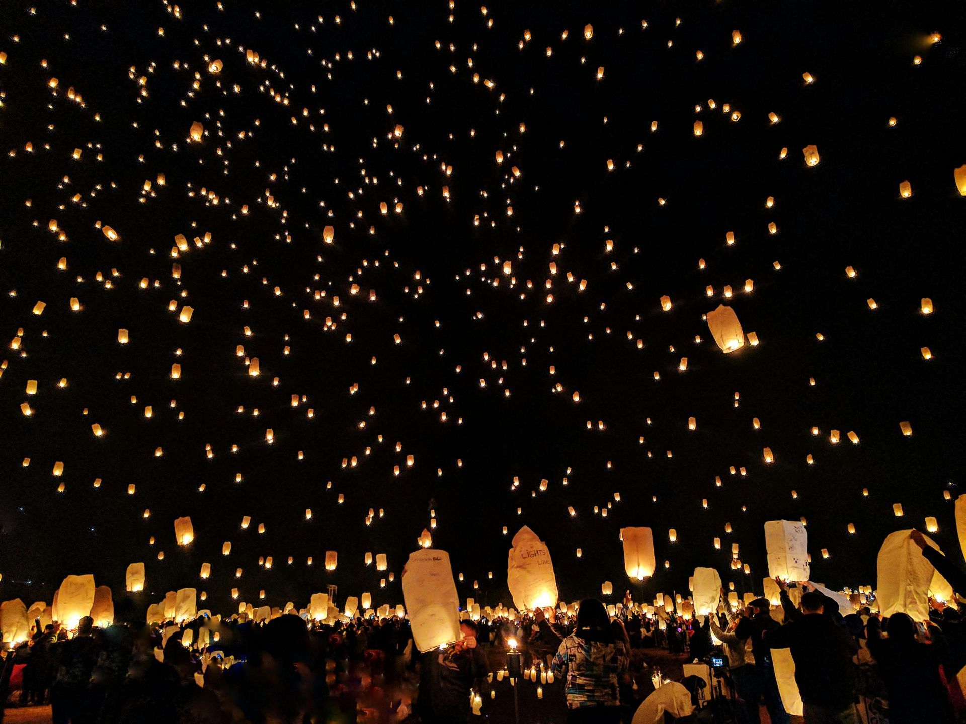 Many lanterns are flying in the night sky