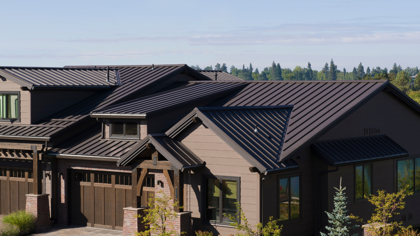 Suburban house roofs with dark tiles and solar panels on a clear day