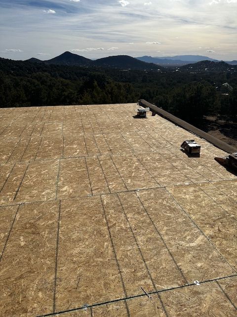 Flat rooftop with dark green mountains and a hazy sky in the distance.