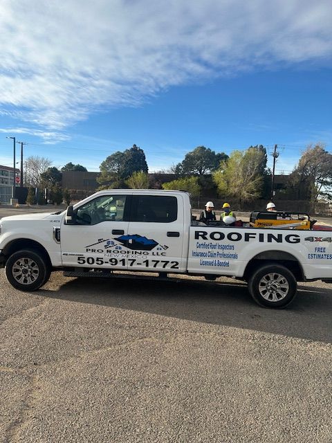 White roofing service pickup truck with logo and phone number parked outdoors on a sunny day