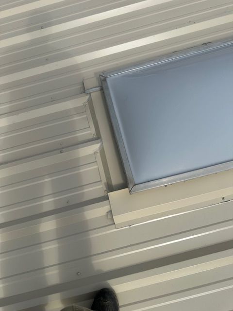 Ceiling with white corrugated panels and a rectangular skylight or light fixture in the corner