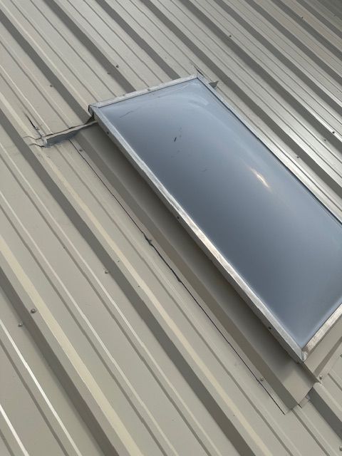 A skylight window on a corrugated metal roof.