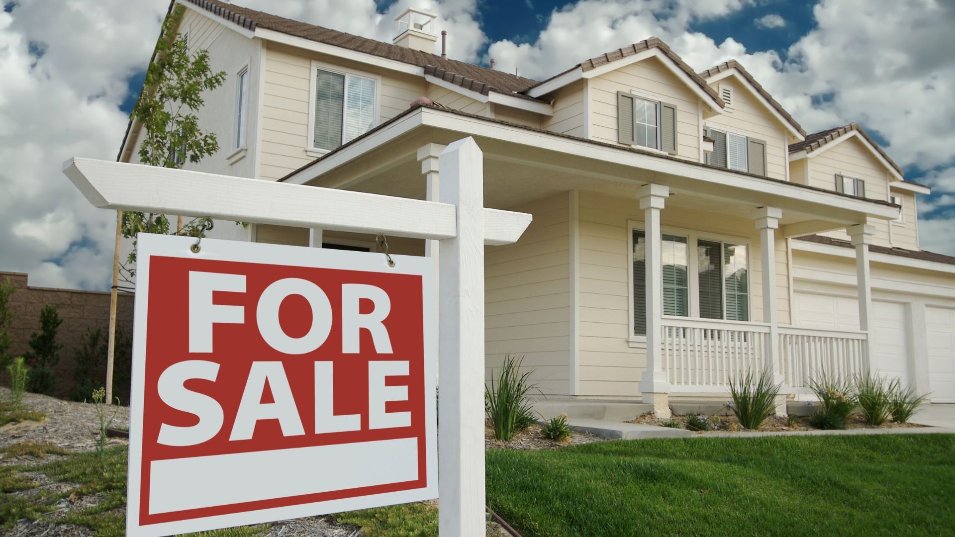 For sale sign in front of house