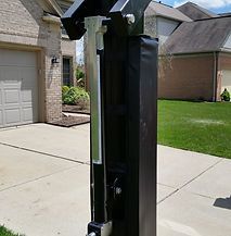 A basketball hoop is sitting on the sidewalk in front of a house.