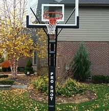A basketball hoop is sitting in front of a brick house.
