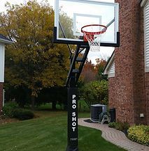 A basketball hoop is sitting in front of a brick house.