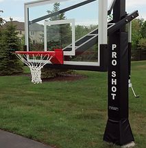 A basketball hoop is sitting on top of a lush green field.