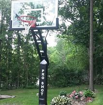 A basketball hoop in a backyard with trees in the background.