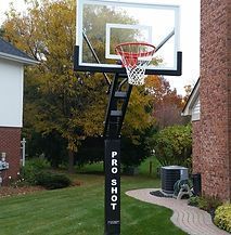 A basketball hoop is sitting in front of a brick house.