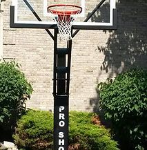 A basketball hoop is sitting in front of a brick building.
