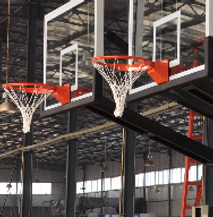 A basketball hoop is hanging from the ceiling of a building