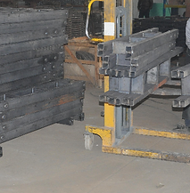 A man is standing next to a forklift in a factory.