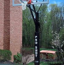 A basketball hoop is sitting in front of a brick building.
