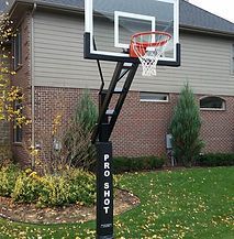A basketball hoop is sitting in front of a brick house.
