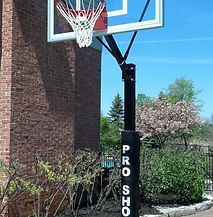 A basketball hoop is sitting in front of a brick building.