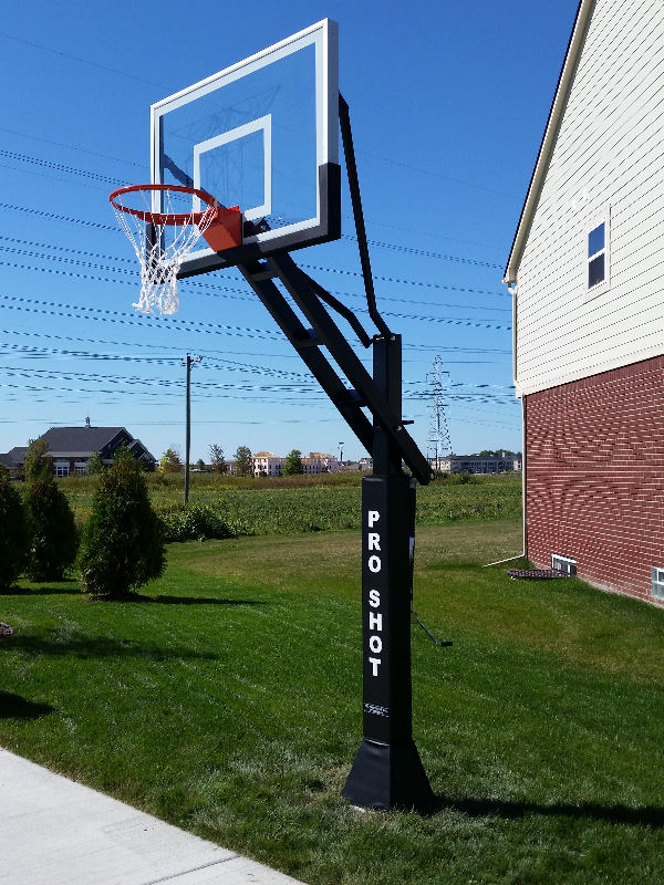 A man is jumping in the air to catch a basketball in a basketball hoop.