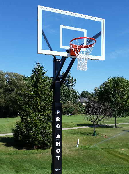 A basketball hoop against a blue sky with clouds