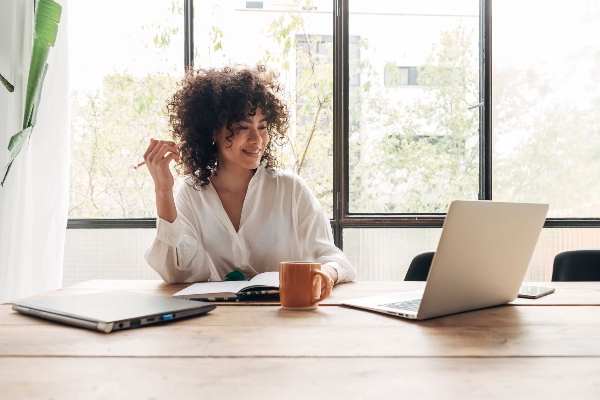 Woman sitting at a table looking at her laptop