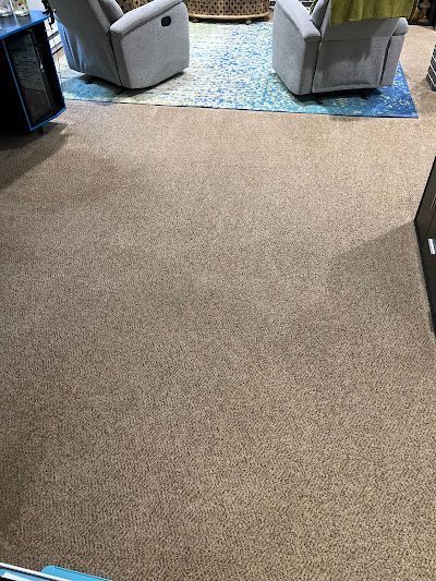 Beige carpet in a living room, with two gray recliners visible in the background.